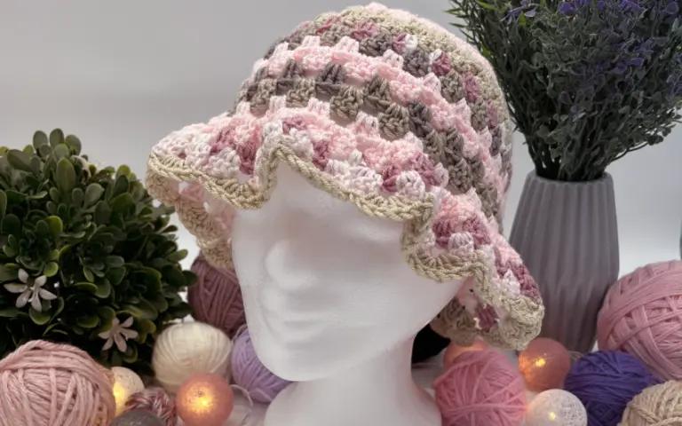 Bunter Bucket Hat auf weißem Modellkopf mit Garnarrangement.