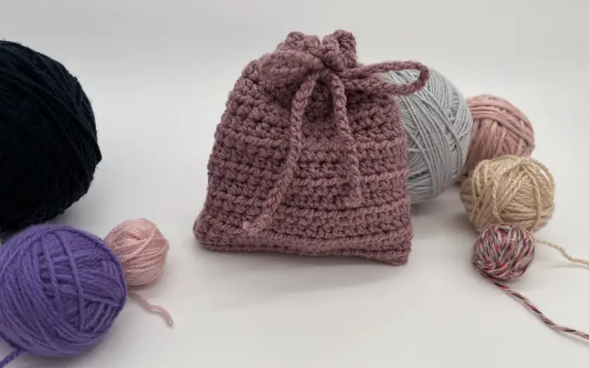 Kleiner gehäkelter Beutel mit Kordel und Garn