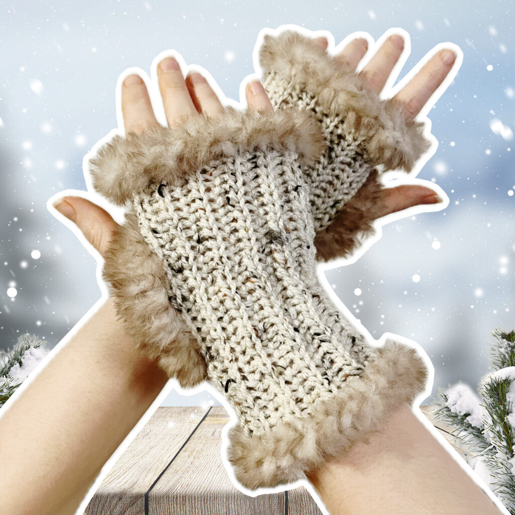 Hände mit gestrickten fingerlosen Handschuhen mit Fellbesatz vor einer winterlichen Schneelandschaft